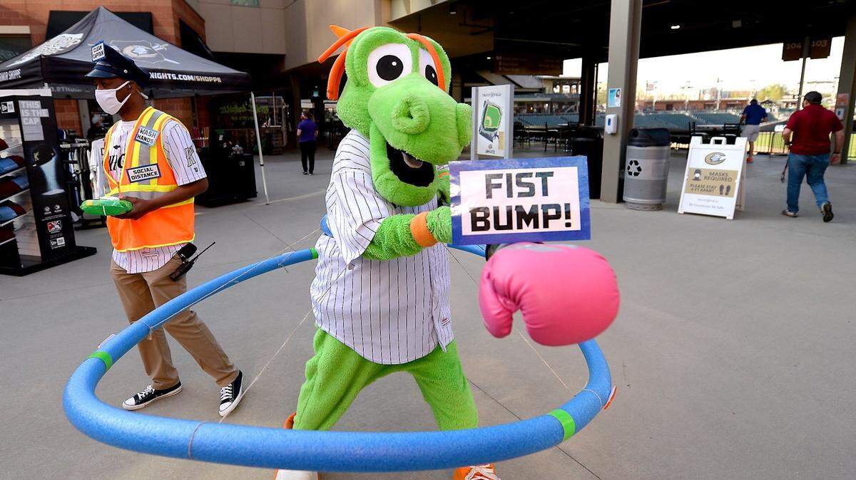 Charlotte Knights mascot Homer the Dragon anticipates bumping fists with a fan as they enter Truist Field in Charlotte on April 6 ahead of the UNC-South Carolina game. The Knights will play Tuesday for the first time since 2019.