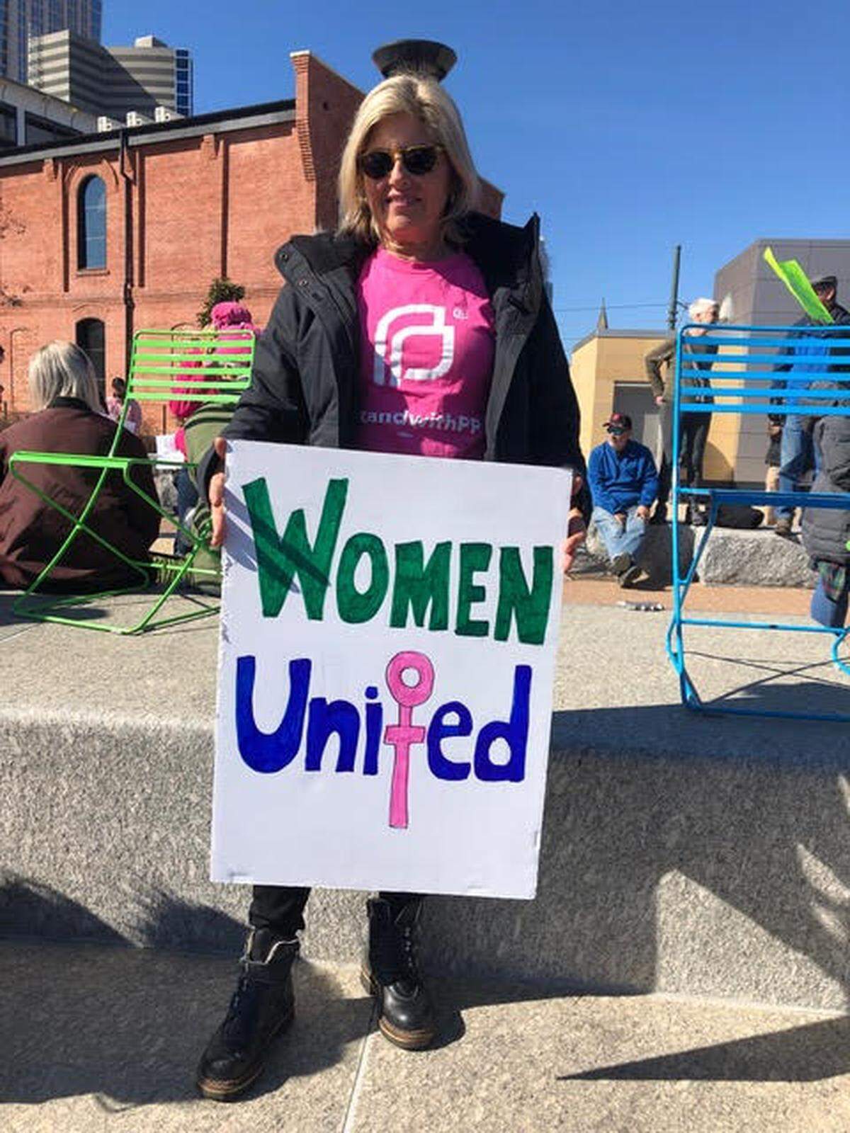 Marcie Shealy poses with a handmade sign at a protest for women’s rights.