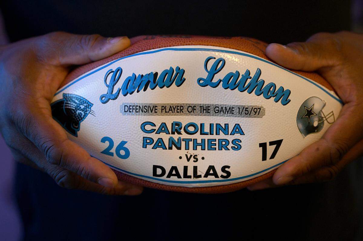 Former Carolina Panthers linebacker Lamar Lathon holds one of the game balls he received during his career on Friday, November 18, 2022. Lathon was drafted by the Houston Oilers in 1990. Lathon played with the Carolina Panthers from 1995 until 1998. He made the Pro Bowl in 1996.