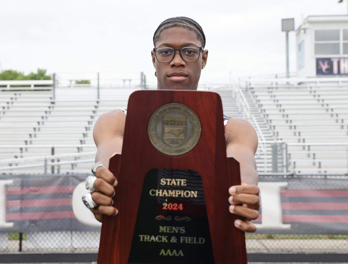 Mallard Creek High School track standout Nyan Brown holds a championship trophy at the school on Monday, May 11, 2026.