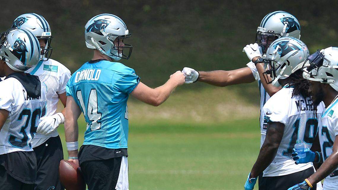Carolina Panthers quarterback Sam Darnold, left/center, fists bumps the wide receivers prior to a series of drills during the teamÕs OTA practice on Tuesday, May 25, 2021.