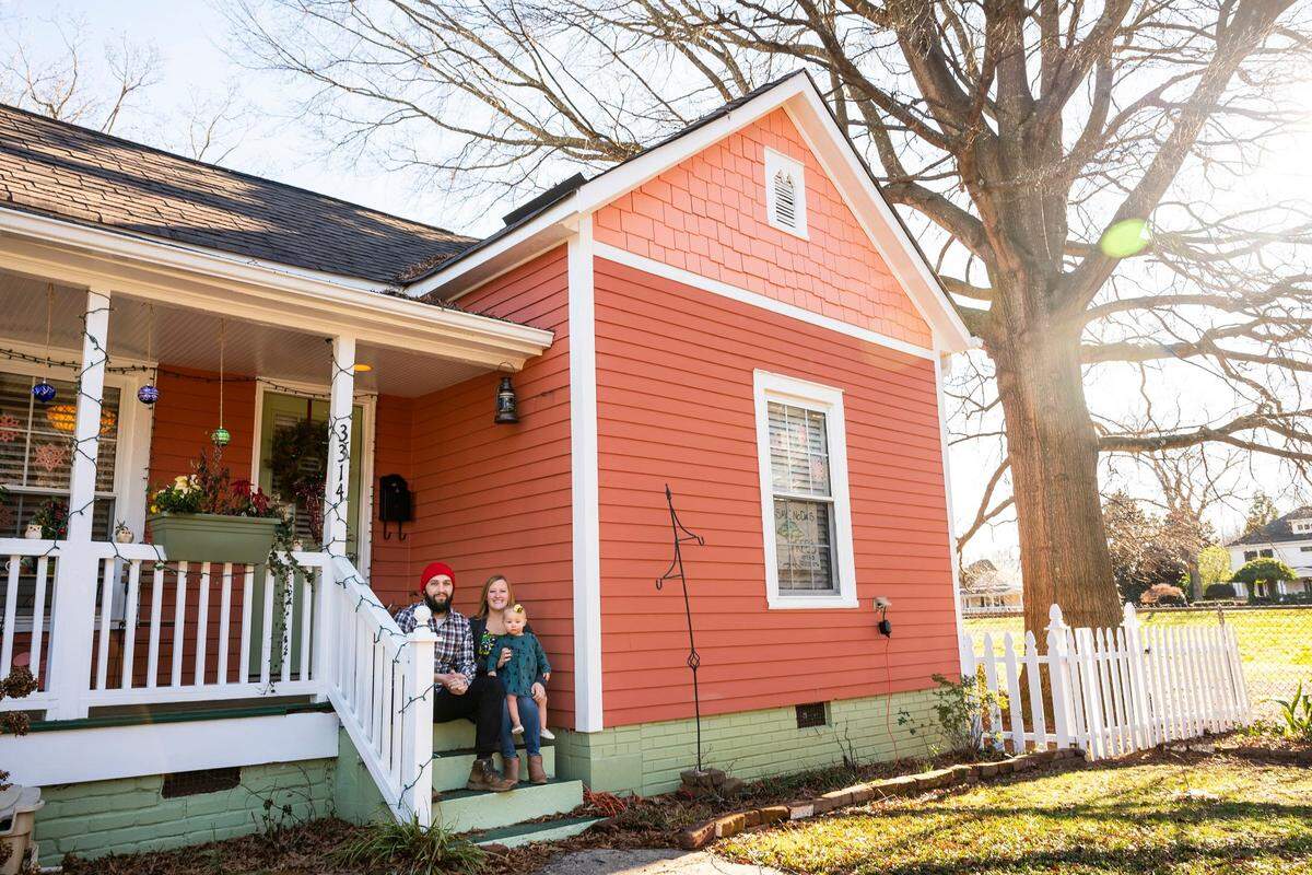 Jason Newton, his wife, Krysten Reilly and their fourteen-month-old daughter, Delia Newton, pose for a portrait outside their home on Monday, January 10, 2022 in Charlotte, NC.