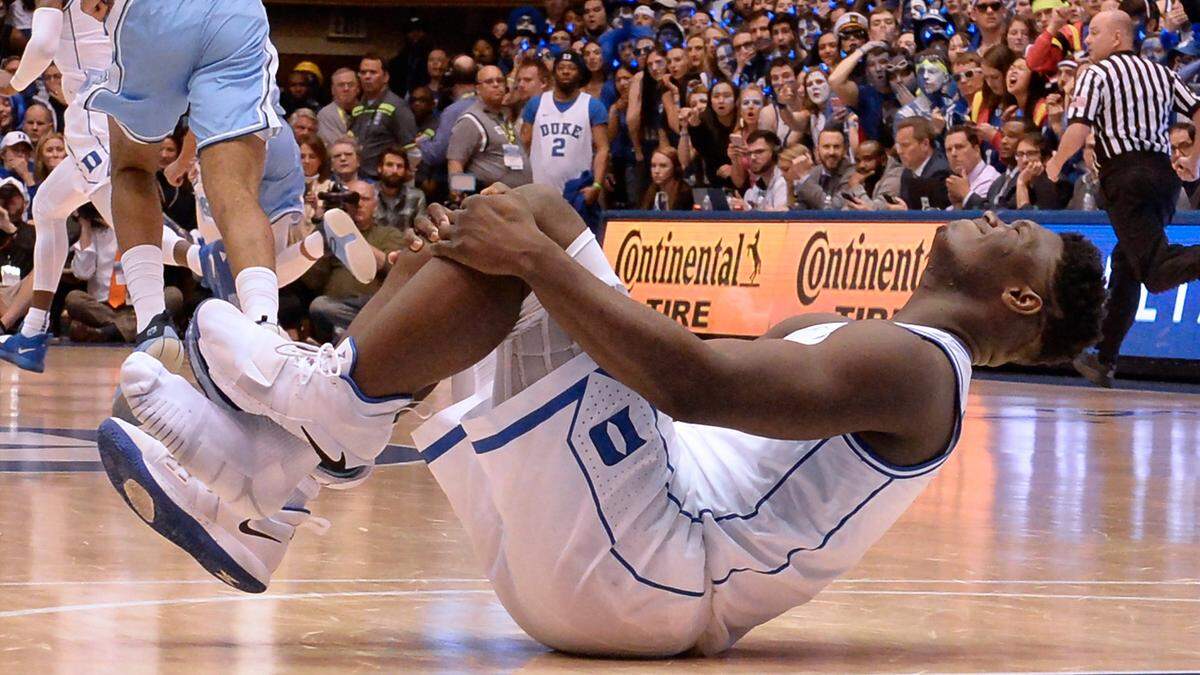 Duke forward Zion Williamson (1) holds his knee after blowing out his shoe early in the game. He did not return in the first half. Duke battled UNC at Cameron Indoor Stadium In Durham, N.C., Wed., Feb.20, 2019.