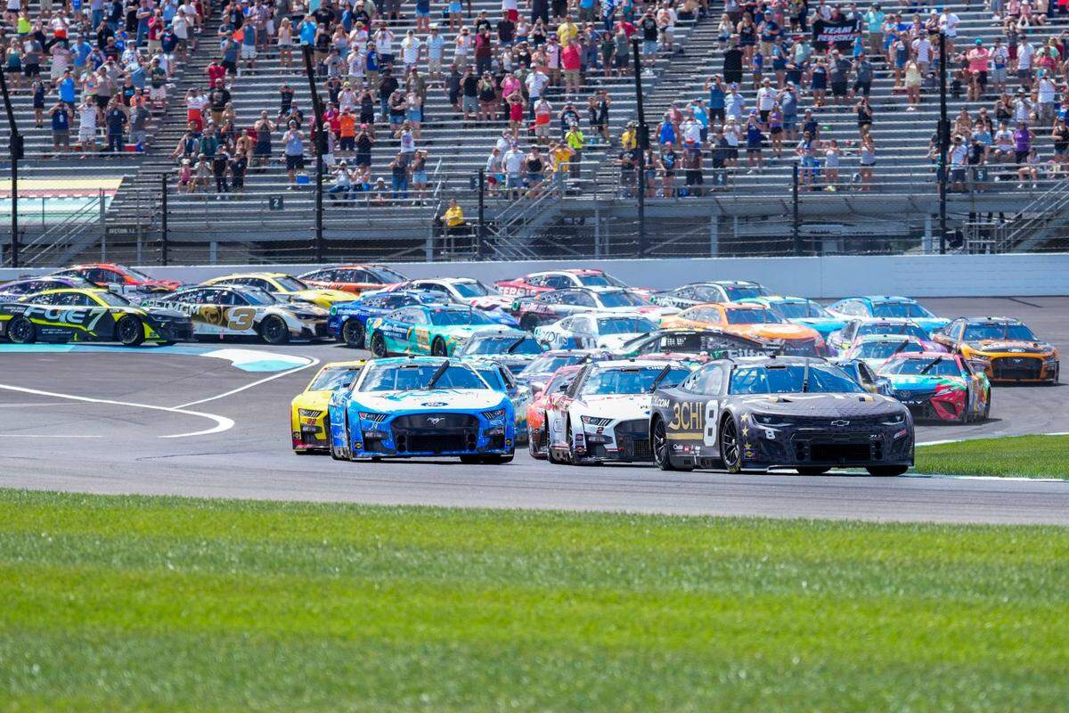 Tyler Reddick (8) leads the pack through the first turn on the opening lap during the running of a NASCAR Cup Series auto race at Indianapolis Motor Speedway, Sunday, July 31, 2022, in Indianapolis. (AP Photo/AJ Mast)