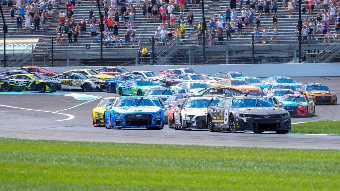 Tyler Reddick (8) leads the pack through the first turn on the opening lap during the running of a NASCAR Cup Series auto race at Indianapolis Motor Speedway, Sunday, July 31, 2022, in Indianapolis. (AP Photo/AJ Mast)