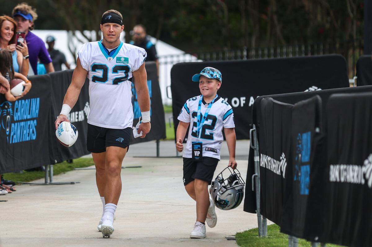 Panthers running back Christian McCaffrey, left, walks out to practice during the Back Together practice in Gibbs Stadium at Wofford College on Saturday, July 30, 2022 in Spartanburg, SC. 