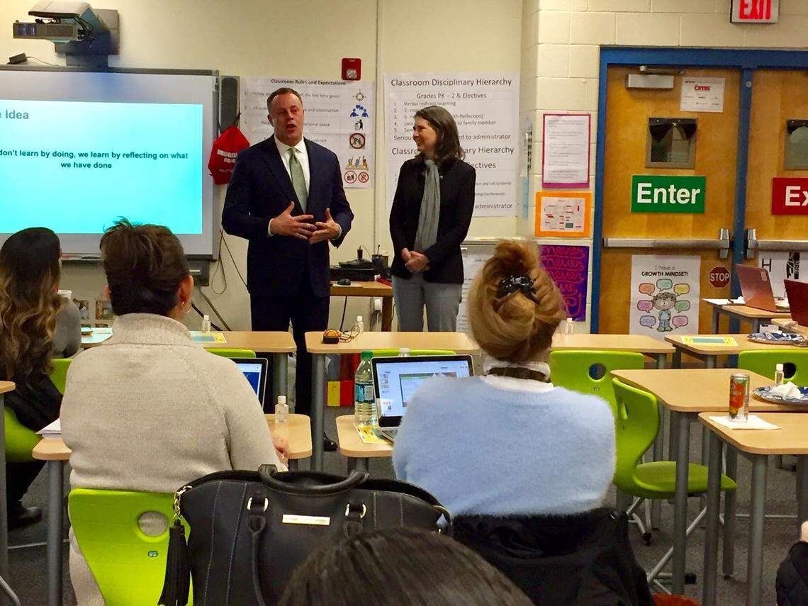 Jay Everette, senior community relations manager for Wells Fargo (left), and Anna Spangler Nelson, co-chair of Project LIFT, tell principals about the opportunity to attend a Harvard urban education program this summer.