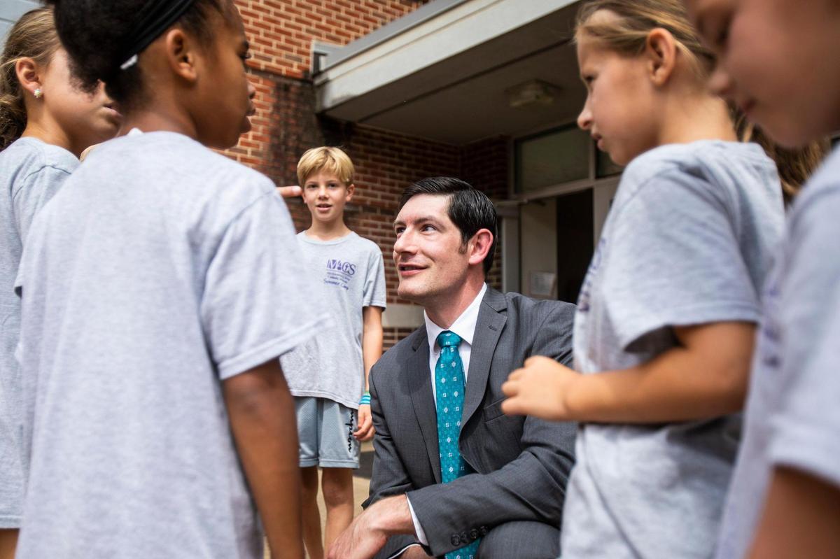 Dr. Gregory Monroe, Superintendent of Catholic school for the Diocese of Charlotte, squats down to speak with children attending a summer camp at St. Matthew Catholic School last week.