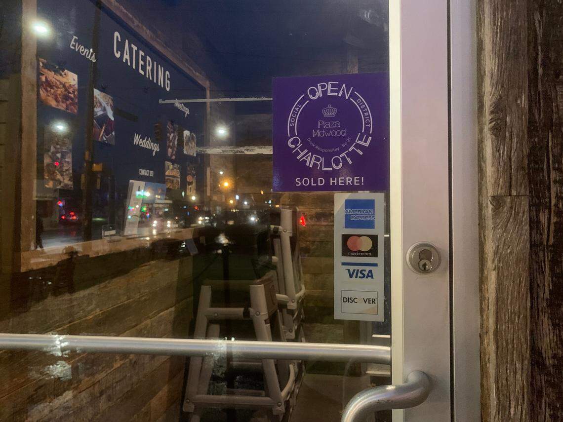 A purple sticker on the front door of Pizza Peel in Plaza Midwood indicates the restaurant is participating in the neighborhood’s social district and that patrons can purchase special social district cups inside.