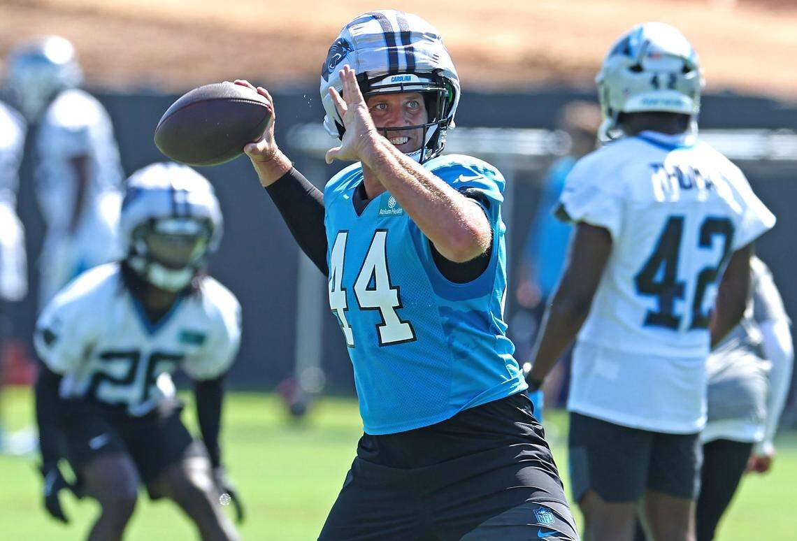 Carolina Panthers long snapper JJ Jansen, center, drops back to pass during a recent training camp practice.