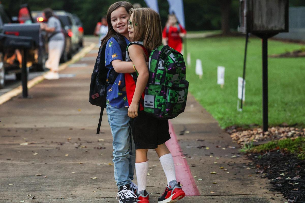 Friends hug each other as they arrive for the frist day of school at Waxhaw Elementary School on Monday, August 28, 2023.
