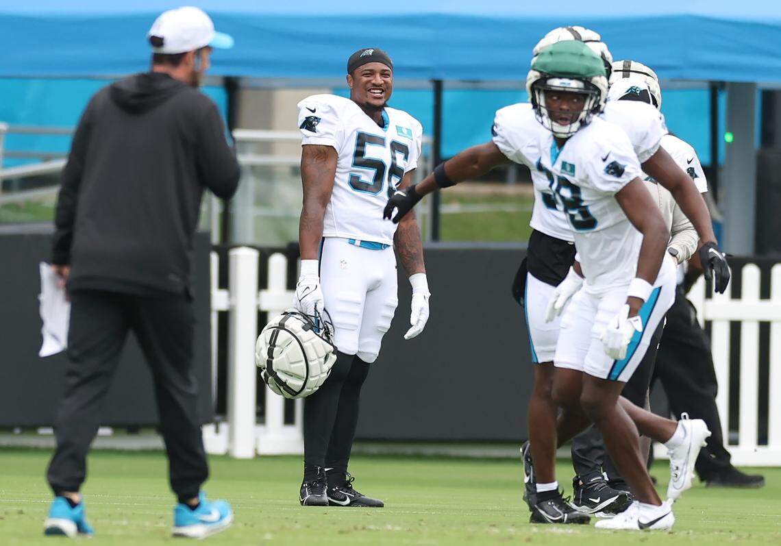 Carolina Panthers linebacker Trevin Wallace, center, smiles as he watches his teammates run through a series of drills during practice on Tuesday, August 6, 2024.
