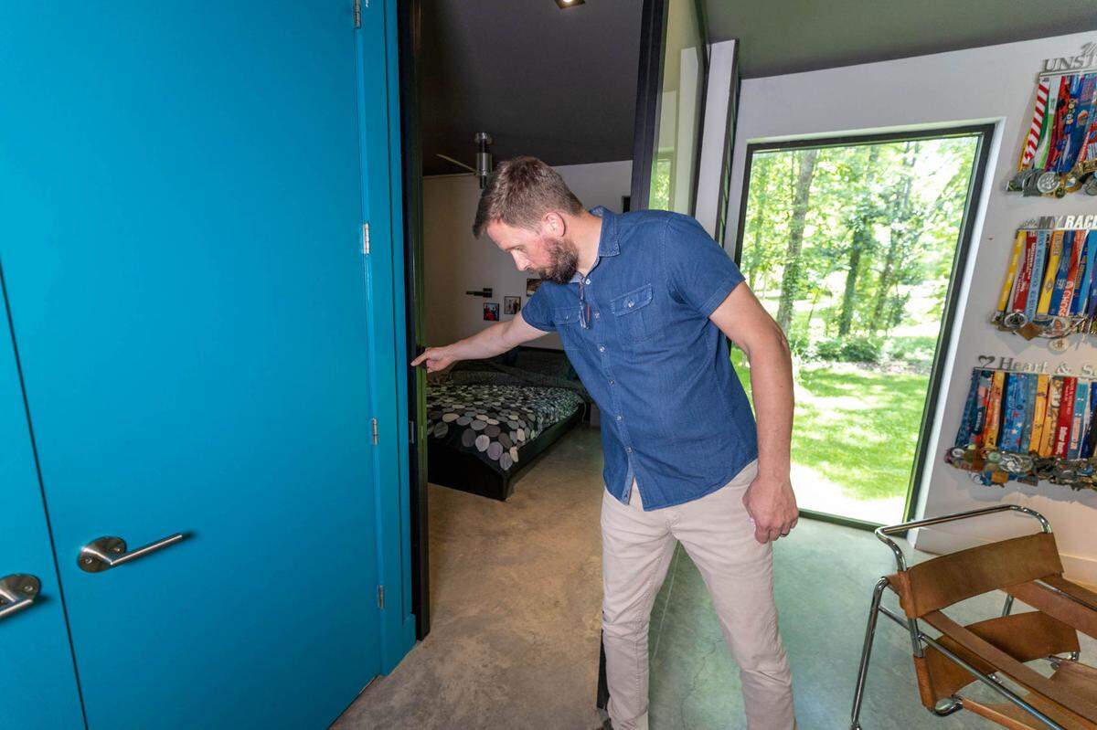 Toby Witte closes off the sliding walls that create an entrance to his master bedroom.