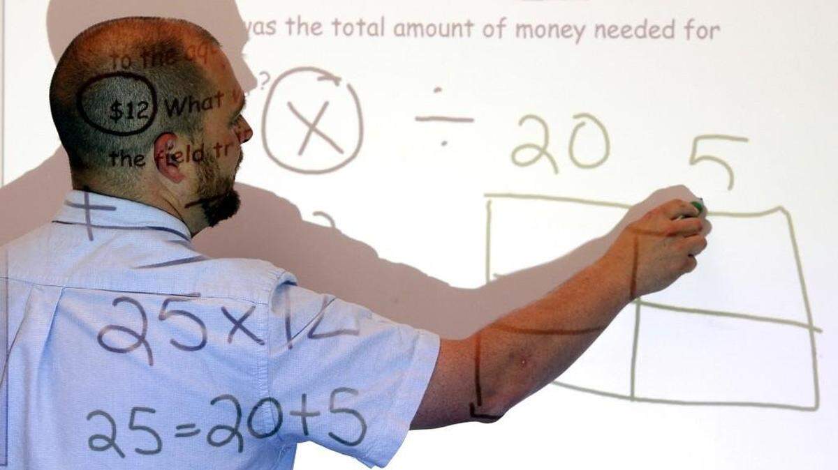 Nationally Board Certified 4th Grade Teacher Brian Pattison, 41, works on a math problem for his students in 2013 at the Lake Myra Elementary School in Wendell, N.C..