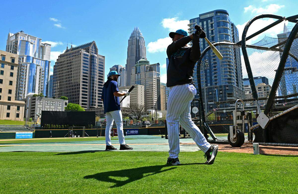 The Charlotte, NC skyline provides the backdrop as the Charlotte Knights take batting practice during the team’s media day on Wednesday, March 29, 2023 at Truist Field in Charlotte, NC.