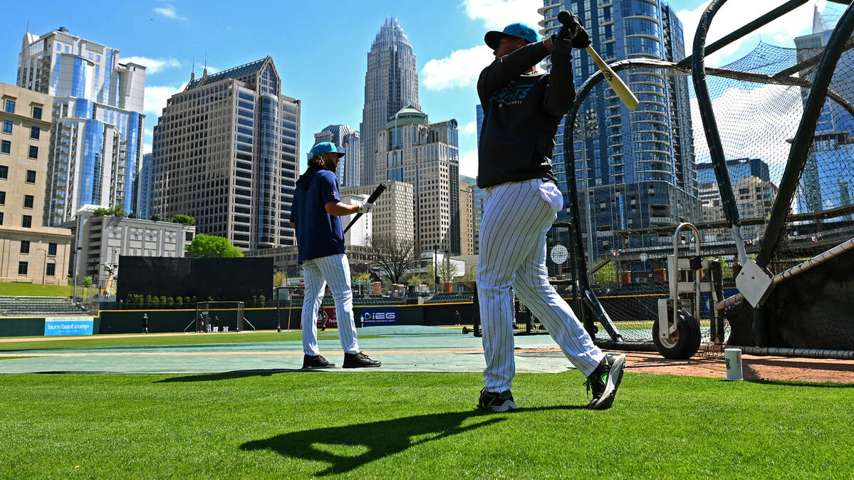 The Charlotte, NC skyline provides the backdrop as the Charlotte Knights take batting practice during the team’s media day on Wednesday, March 29, 2023 at Truist Field in Charlotte, NC.