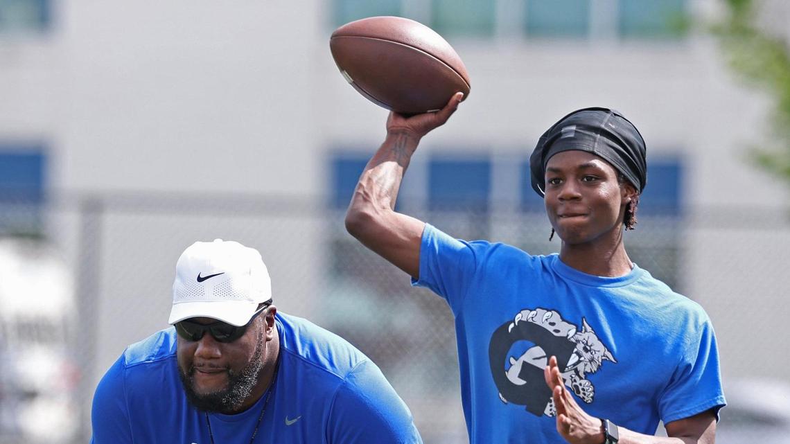 Garinger High School head football coach Jupiter Wilson, left, watches his players run through a workout on Tuesday, April 29, 2025. Garinger High School has been through dozens of coaches trying to turn the program around. Now, the former UNC football player is taking his turn.