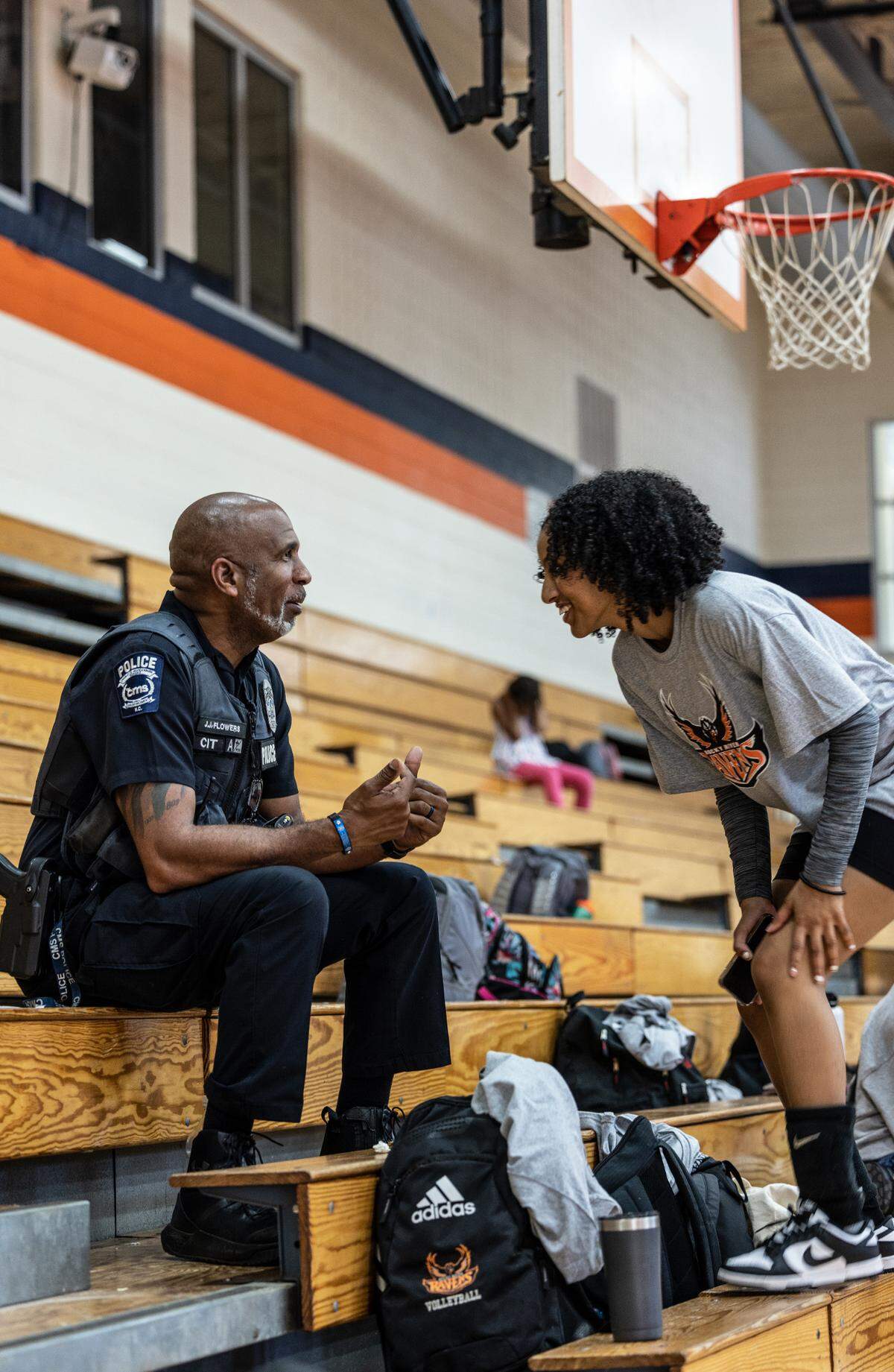 Officer J.J. Flowers, left, talks to a volleyball player at Julius L. Chambers High School in Charlotte earlier this week.