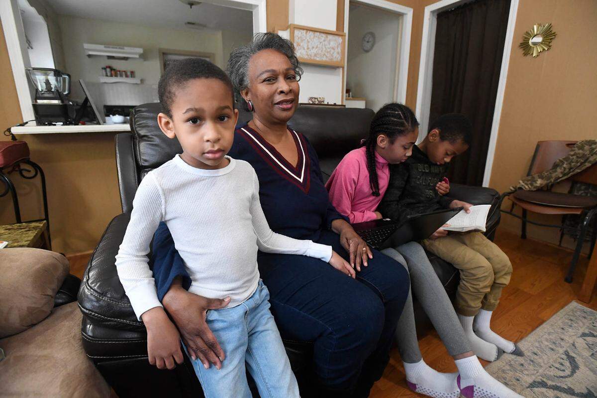 Regina Barrett, center, sits with her grandchildren Asa Barrett, left, 5, Hallie Barrett, 10, and Asher Barrett, 8, in her Monroe, NC home on Wednesday, February 10, 2021.