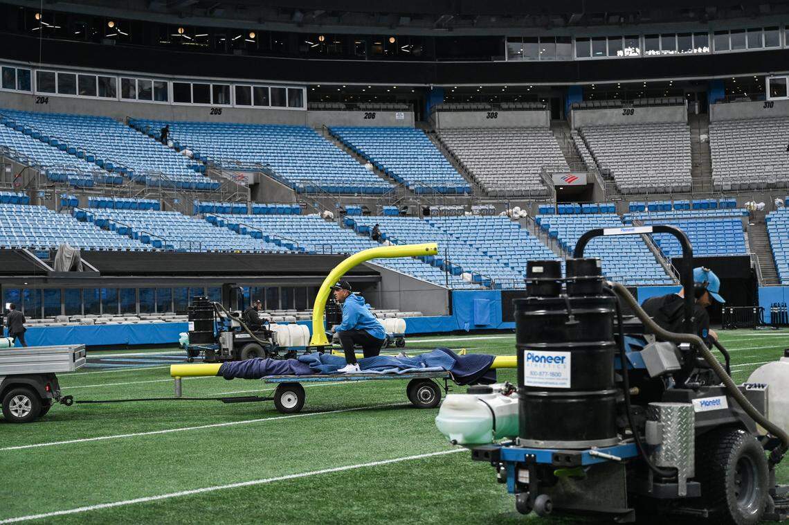 Stadium operations crew work diligently to start transitioing the field from an NFL game and prepping it for an MLS game at Bank of America Stadium in Charlotte, NC on Sunday, October 26, 2025. The beginning stages of prep include dismantling and removing goal posts, scrubbing the field of markings for an NFL game, removing team benches from the sidelines and placing shelters and seating for MLS teams.