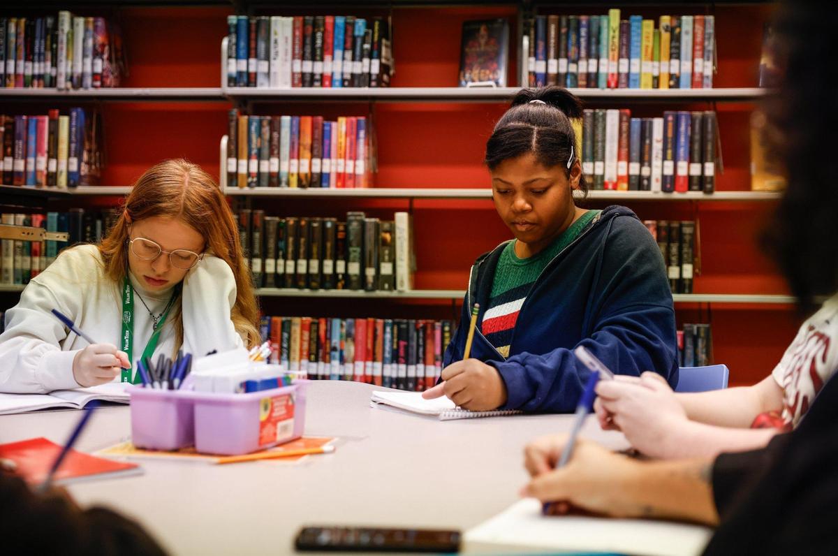 Elena Lane, left, and Nyla Clyburn put their thoughts on paper after being given a writing prompt during Inkspill, a writing club at the Charlotte Mecklenburg Library — University City Regional branch.