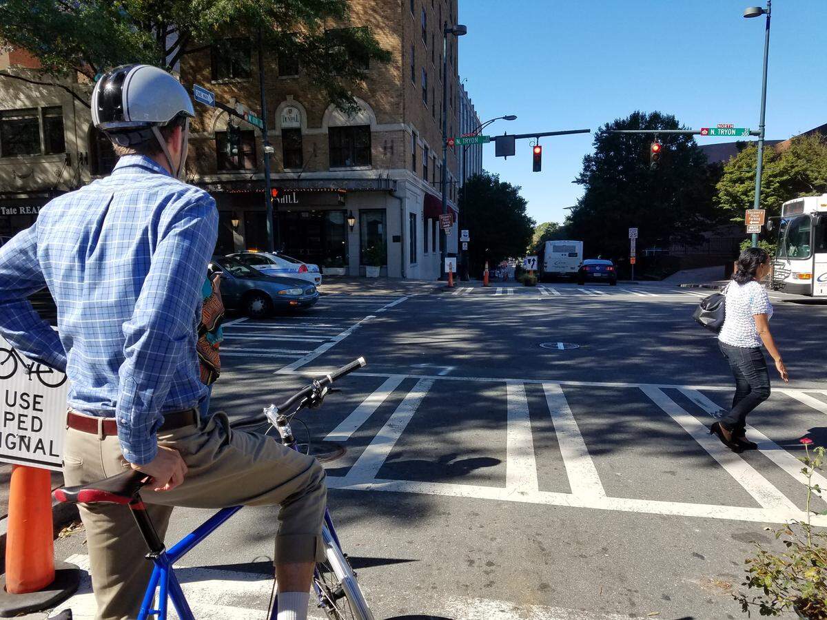 Ben Miller of the Charlotte Department of Transportation rides a bicycle in a protected bike-lane demo on Oct. 24.