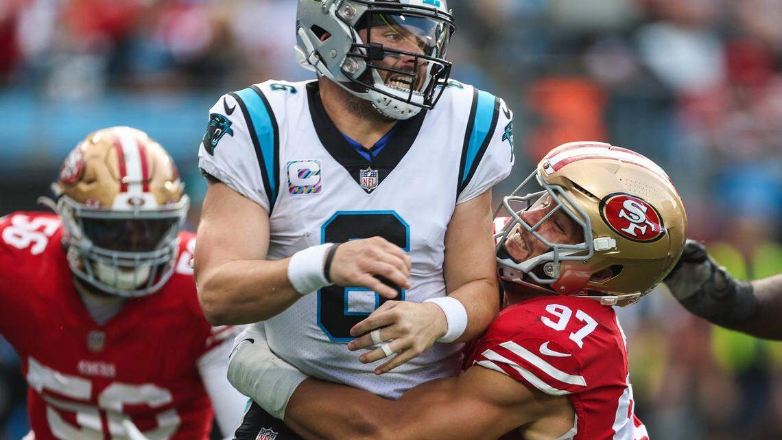 49ers defensive lineman Nick Bosa, right, wraps his arms around Panthers quarterback Baker Mayfield during the game at Bank of America Stadium on Sunday, October, 9, 2022.