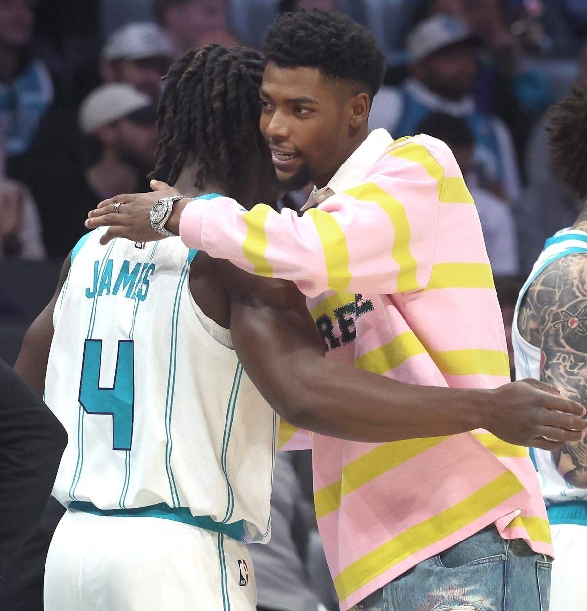 Charlotte Hornets guard Sion James, left, is hugged by injured guard Brandon Miller prior to the team’s game against the Orlando Magic at Spectrum Center in Charlotte, North Carolina, on Oct. 30, 2025.