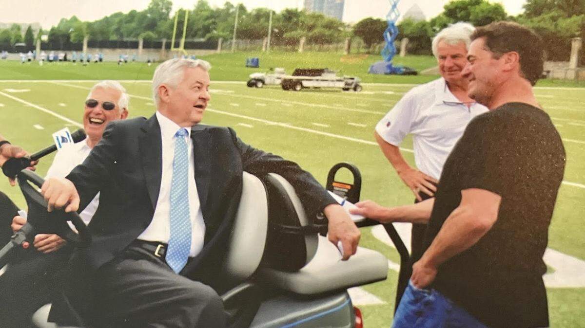 Carolina Panthers founder Jerry Richardson (center, driving golf cart) talks to former Charlotte Observer sports columnist Tom Sorensen (black shirt) in an undated file photo taken at the team’s practice fields in Charlotte. Sitting alongside Richardson is Charlotte banker Hugh McColl, who helped finance Bank of America Stadium. In the background, standing in white shirt, is longtime Panthers public relations man Charlie Dayton. Richardson died on Wednesday, March 1, 2023, at the age of 86.