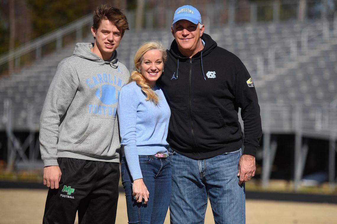 Deems May III, with his mother Susan May and father Deems May, all of Charlotte, N.C., on the field at Gus Purcell Stadium at Myers Park High School in Charlotte, Thursday, Feb. 10, 2022.