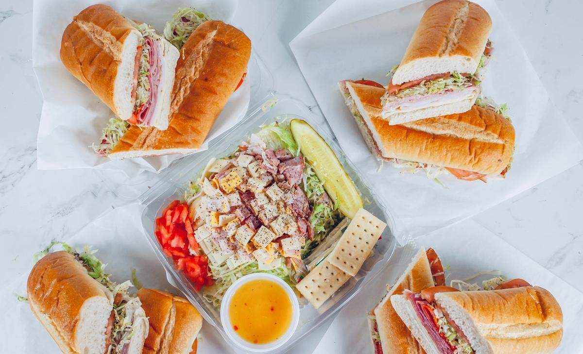 An assortment of sandwiches and a salad from Sandwich Max.