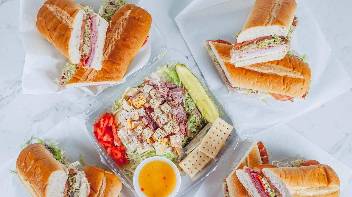An assortment of sandwiches and a salad from Sandwich Max.
