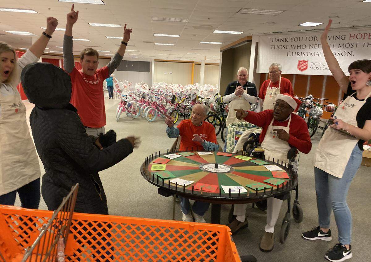 Cheers ring out as a mom spins a wheel and wins a bicycle during the first morning of toy distribution at the Salvation Army Christmas Center. Charlotte-based charity Spokes Group donates hundreds of bikes each year for the program.
