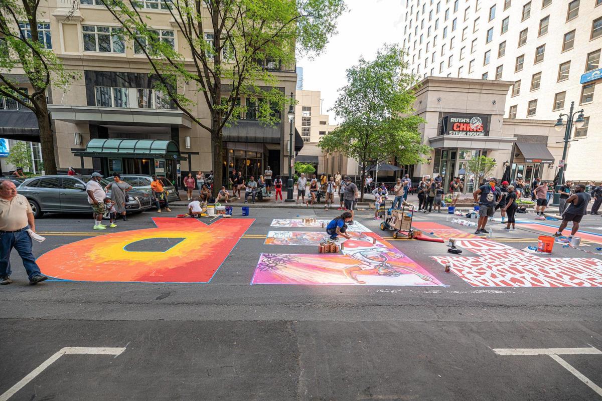 Artists work on their Black Lives Matter street design Tuesday afternoon on North Tryon Street in uptown Charlotte, NC.