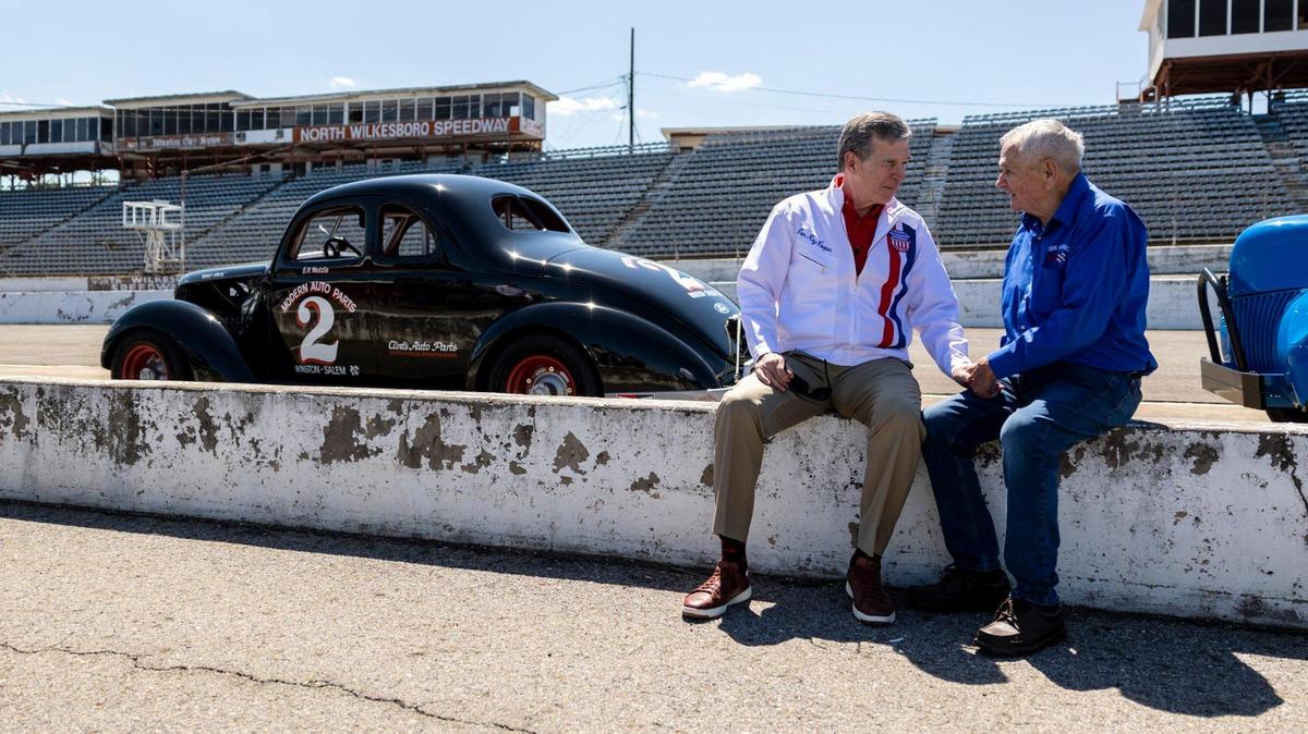 Gov. Roy Cooper talks with Dink Widenhouse after a speech at the Historic North Wilkesboro Speedway in Wilkesboro, NC on Tuesday May 17, 2022. Widenhouse would race throughout North CarolinaÕs dirt tracks and only raced North Wilkesboro once. He was able to get a pole position in qualifying although finished 19th in the race. The speedway has not hosted a race for many years but was once common stop for early racing in the Carolinas before it evolved into NASCAR. Federal money given to North Carolina will go towards the revitalization of the speedway and will be a catalyst for other events in Wilkes county.