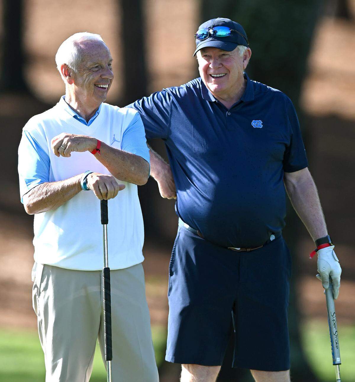 Former UNC head basketball coach Roy Williams, left and head football coach Mack Brown joke around on the second green during the Wells Fargo Championship Pro-Am Wednesday.