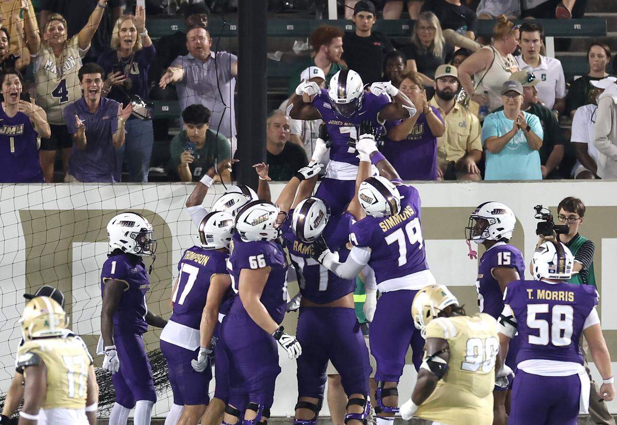 James Madison University running back Aye Adeyi is lifted into the air by his teammates following his touchdown run against the Charlotte 49ers during action on Saturday, August 31, 2024 at Jerry Richardson Stadium.