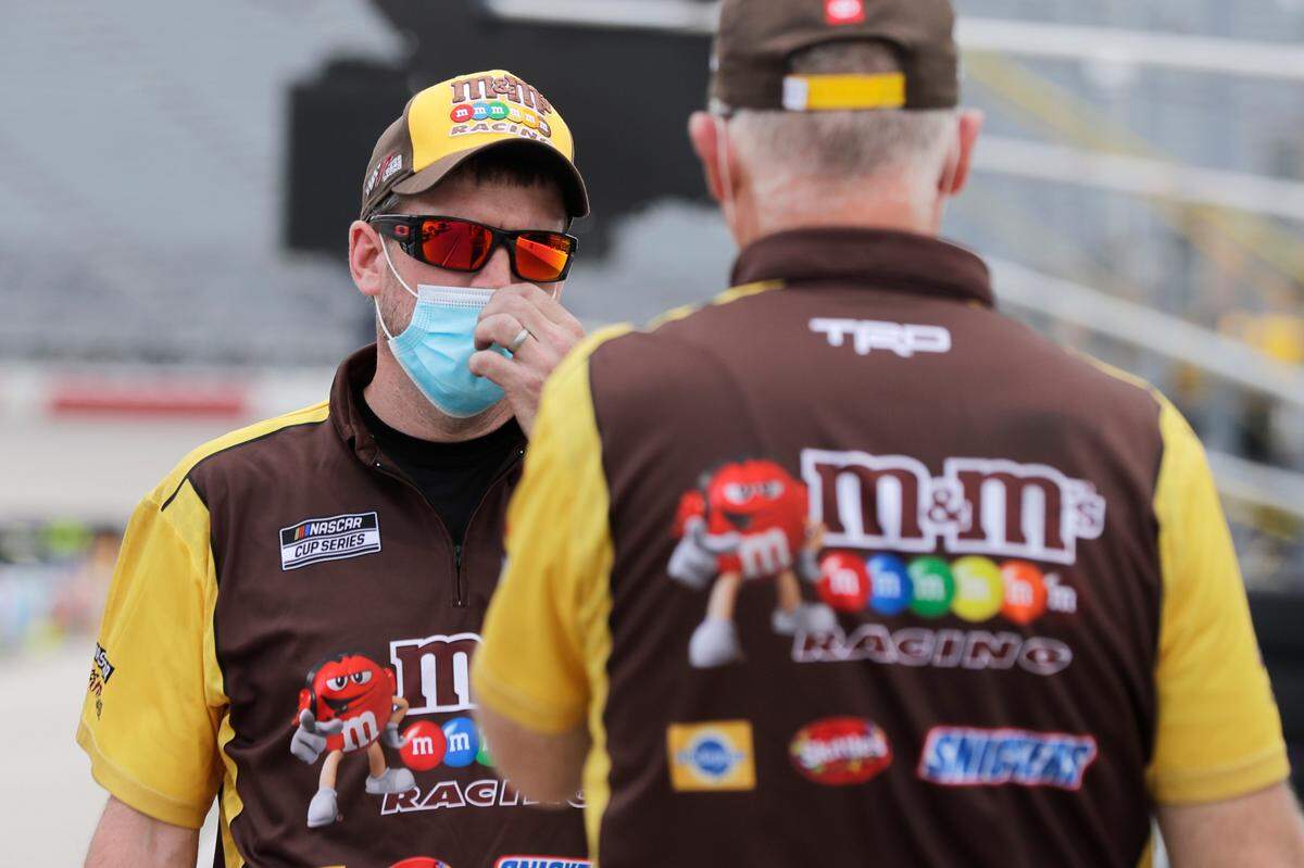 Crew members for driver Kyle Busch talk in pit row before the NASCAR Cup race Sunday in Darlington, which was run without fans.