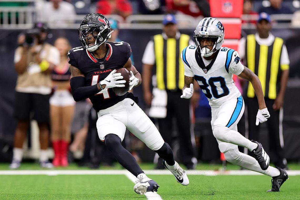 Damon Arnette of the Houston Texans makes an interception against Jacolby George of the Carolina Panthers during the 2025 preseason.