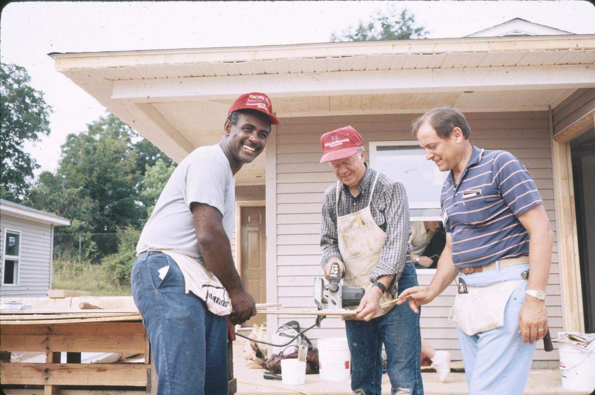 Former Charlotte Mayor Harvey Gantt (left) works with former President Jimmy Carter (center) in 1987 on building homes in Charlotte for Habitat for Humanity.
