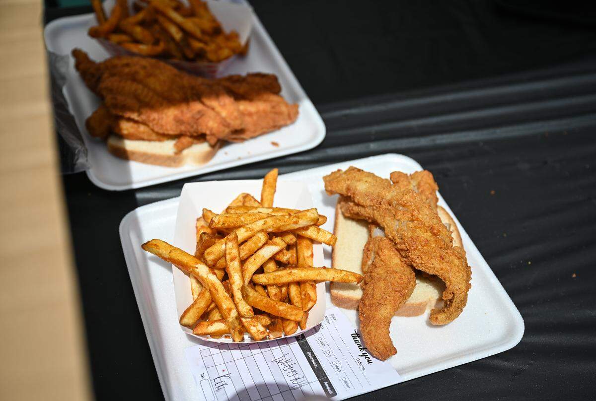 A long line of people waited for Another?! Foodtruck’s Another?! Fish plate with whiting or catfish, served with seasoned fries, during the West Side Fish Fry at West Complex in Charlotte on Saturday, April 18, 2026.