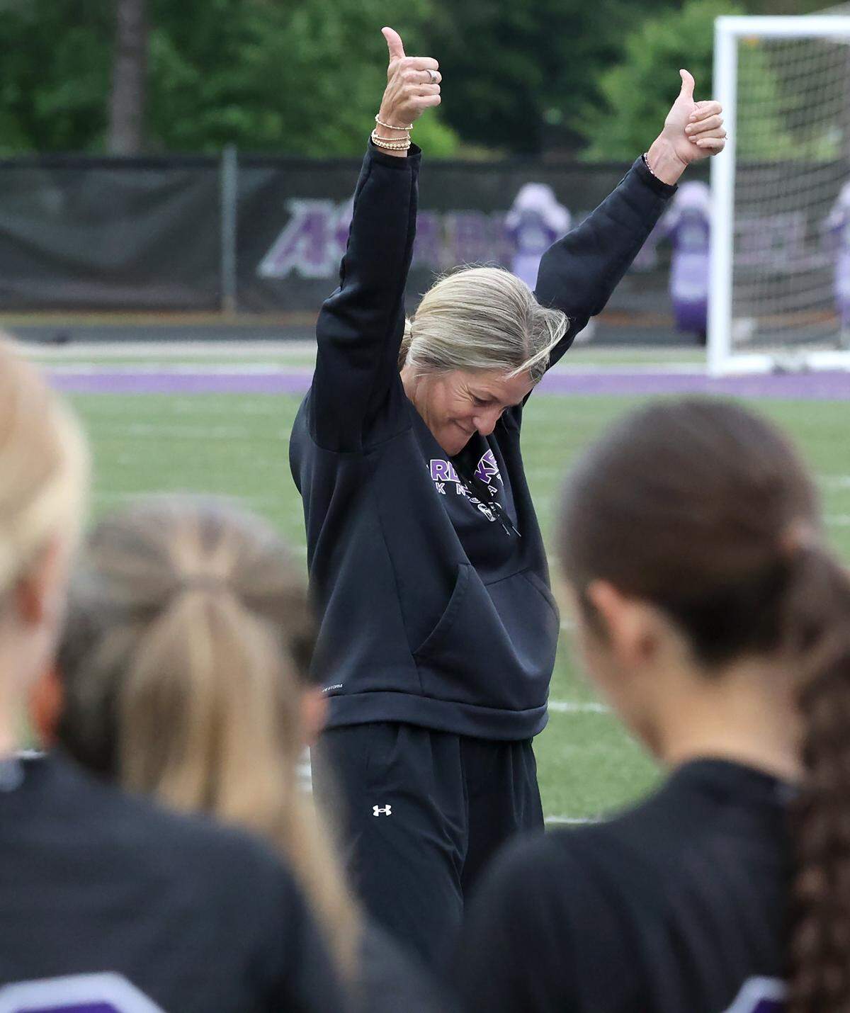 Ardrey Kell girls soccer coach Kim Montgomery raises her thumbs in the air as senior players are recognized prior to action against Ballantyne Ridge on Tuesday, April 28, 2026. Ardrey Kell defeated Ballantyne Ridge 1-0.