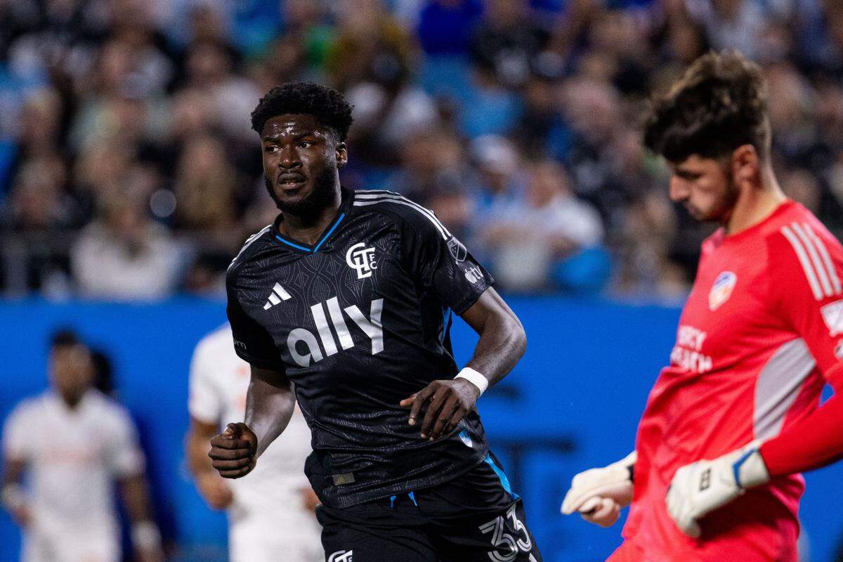 Charlotte FC forward Patrick Agyemang (33) challenges FC Cincinnati goalkeeper Roman Celentano (18) during a March match at Bank of America Stadium.