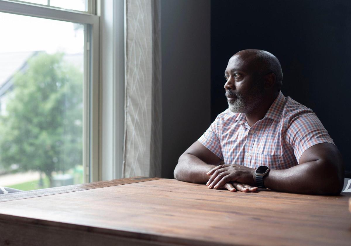 Peter Mutabazi poses in the kitchen of his Charlotte home where he currently houses five foster children and one adopted child. A singe father, Mutabazi has had 34 foster kids.
