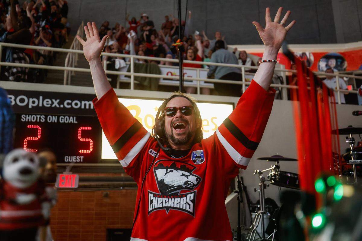 Checkers organist and keytarist Jason Atkins, also known as Greazy Keyz, celebrates a goal during the Calder Cup opener between the Checkers and Canucks at Bojangles Coliseum in Charlotte Friday, June 13, 2025.
