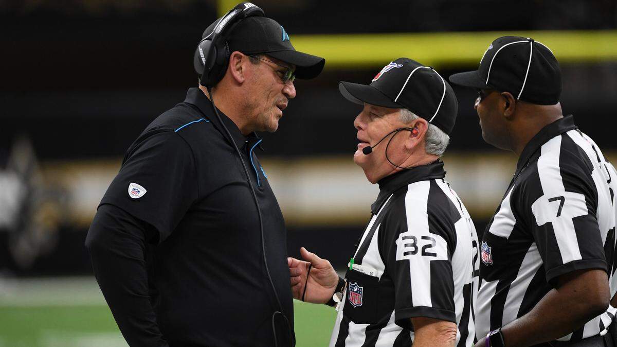 Carolina Panthers head coach Ron Rivera speaks to NFL line judge Jeff Berman (32) and field judge Keith Washington (7), during the second half at an NFL football game against the New Orleans Saints, Sunday, Nov. 24, 2019, in New Orleans. (AP Photo/Bill Feig)