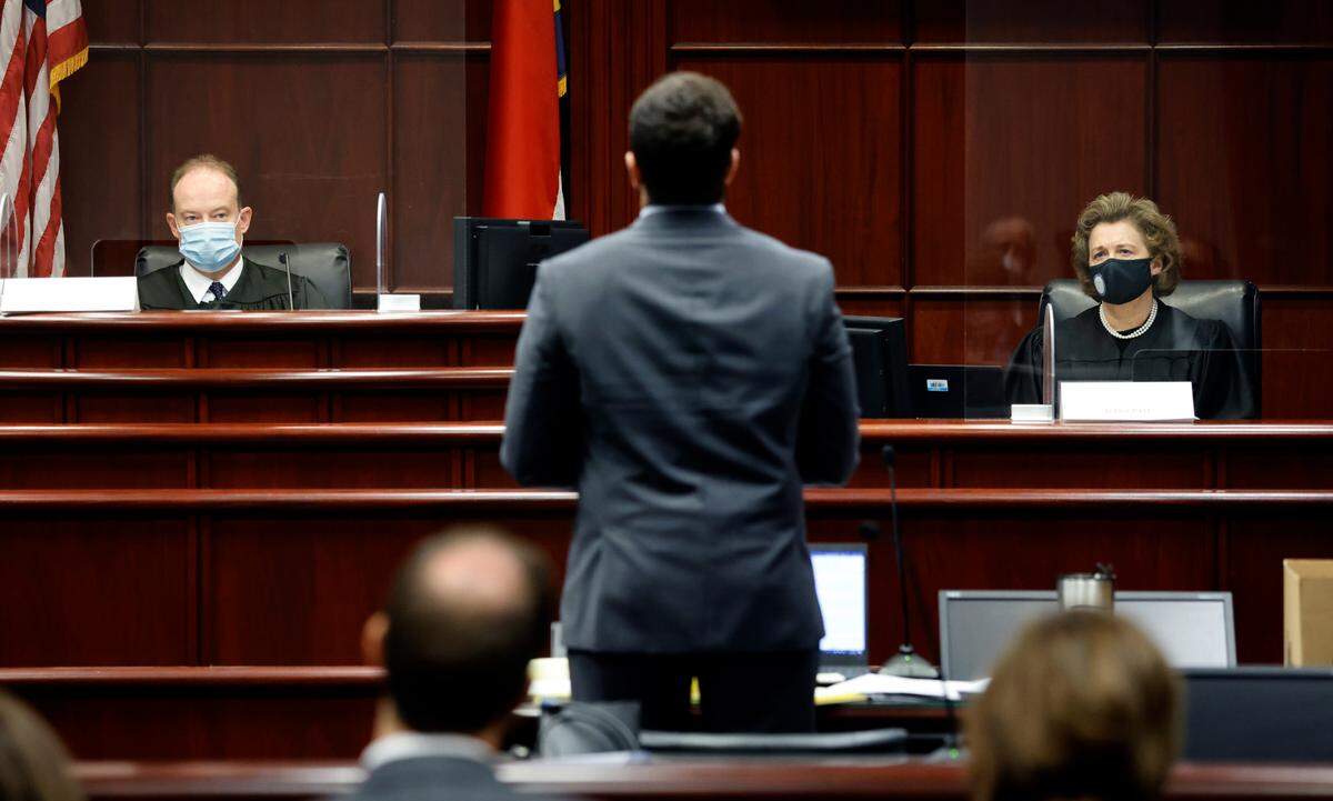 Attorney Christian Ferlan, center, speaks as judges Martin McGee, left, and Imelda Pate listen at the Wake County Courthouse in Raleigh, N.C., Thursday, October 21, 2021. Judges McGee and Pate are part of a three judge panel who listened to arguments Thursday about the constitutionality of temporarily suspending the statute of limitations for child sex abuse lawsuits.