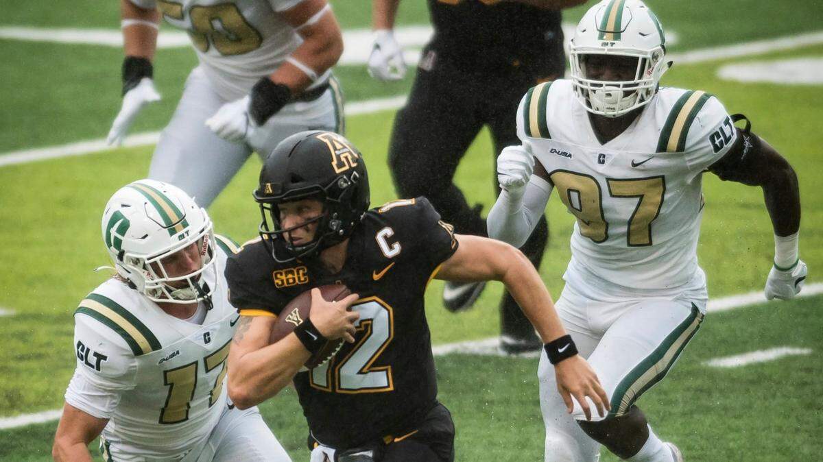 Charlotte 49ers defenders Luke Martin (17) and Damon Weldon (97) pursue Appalachian State quarterback Zac Thomas in the Mountaineers’ 35-20 victory on Sept. 12.