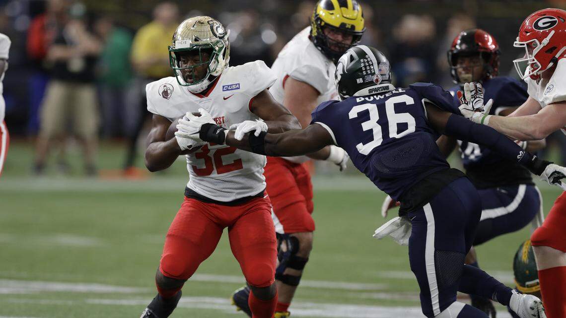 East running back Benny LeMay, of Charlotte, (32) eludes West safety David Dowell, of Michigan State, (36) during the first half of the East West Shrine football game Saturday, Jan. 18, 2020, in St. Petersburg, Fla. (AP Photo/Chris O’Meara)