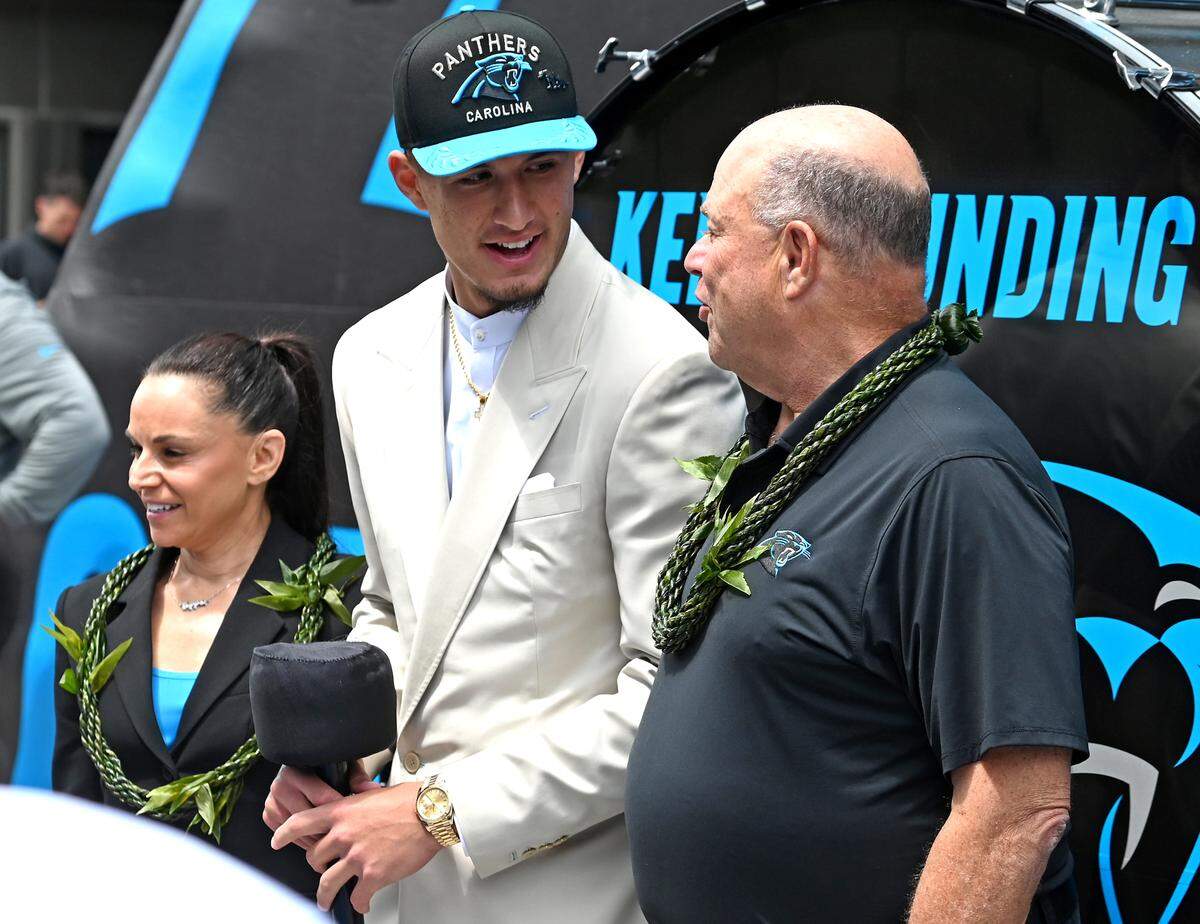 Carolina Panthers draft pick Tetairoa McMillan, center, speaks to team owner David Tepper, right, as Nicole Tepper, left, looks on during a welcoming ceremony outside Bank of America Stadium on Friday, April 25, 2025. The Panthers selected McMillan with the eighth pick in the 2025 NFL Draft.